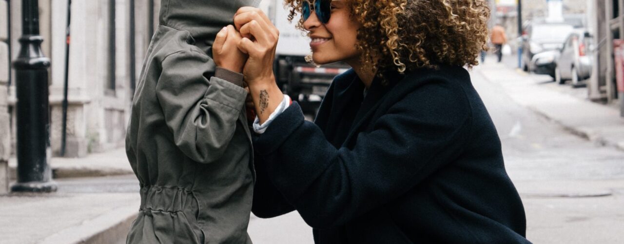 woman holding kid at the street