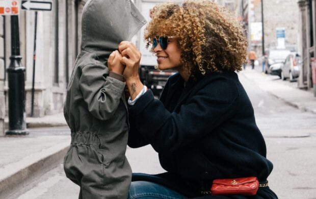 woman holding kid at the street