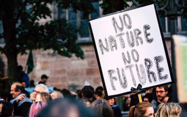 man holding No Mature No Future signage