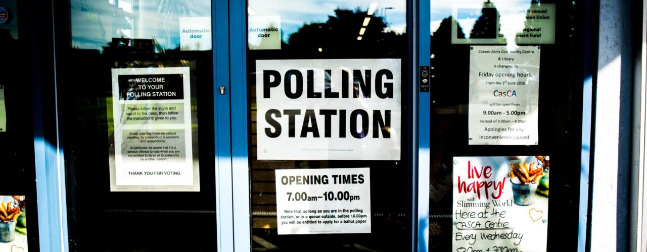 polling station poster on clear glass door