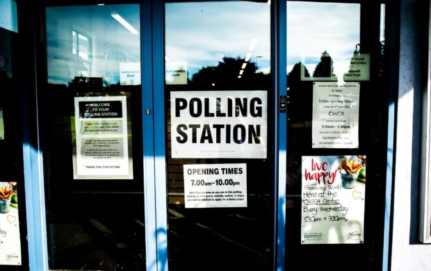 polling station poster on clear glass door