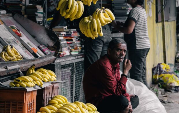 man sitting on chair near bananas