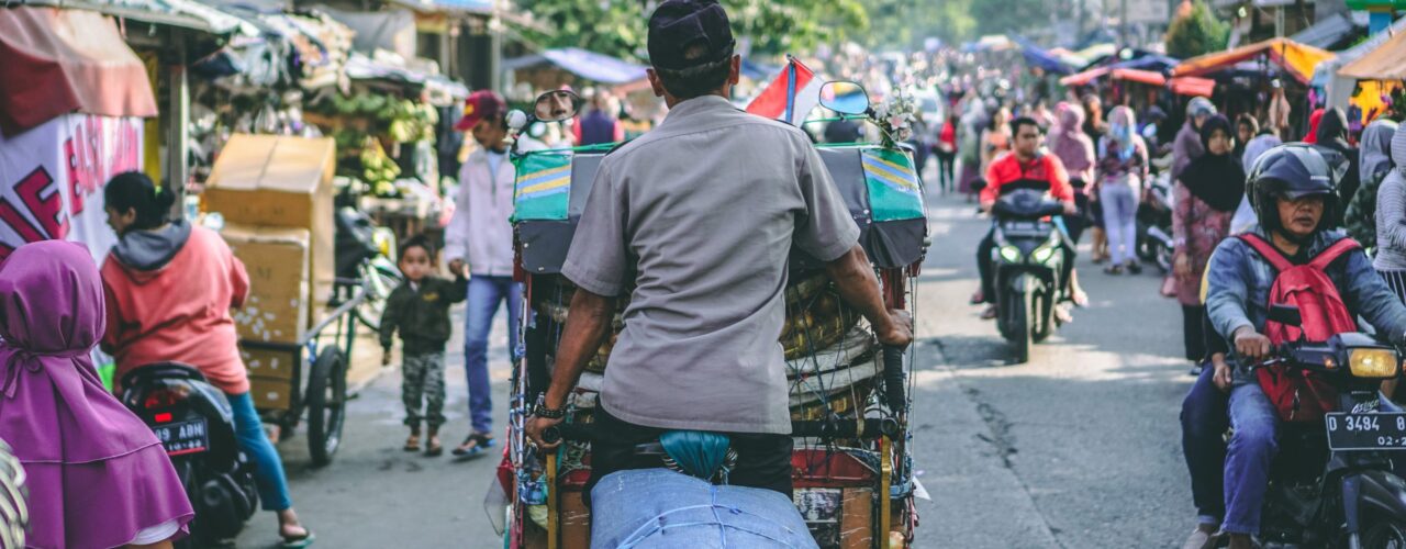 selective photography of man pedaling wagon