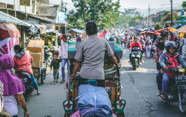 selective photography of man pedaling wagon