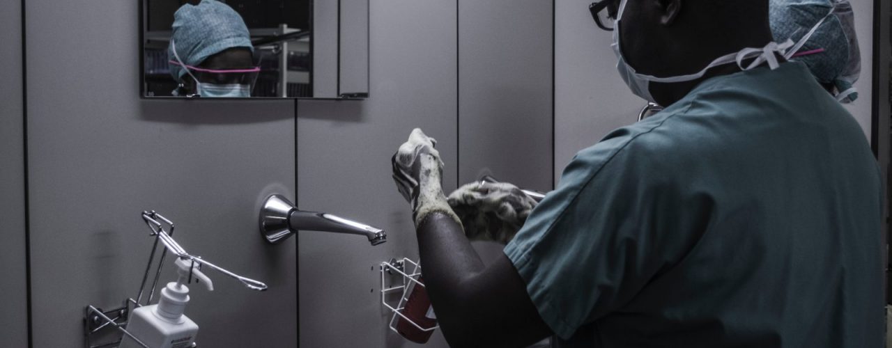 man wearing surgical suit near mirror
