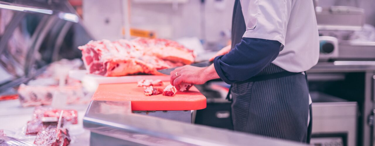 man slicing raw meat