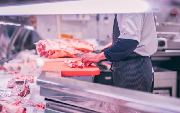 man slicing raw meat