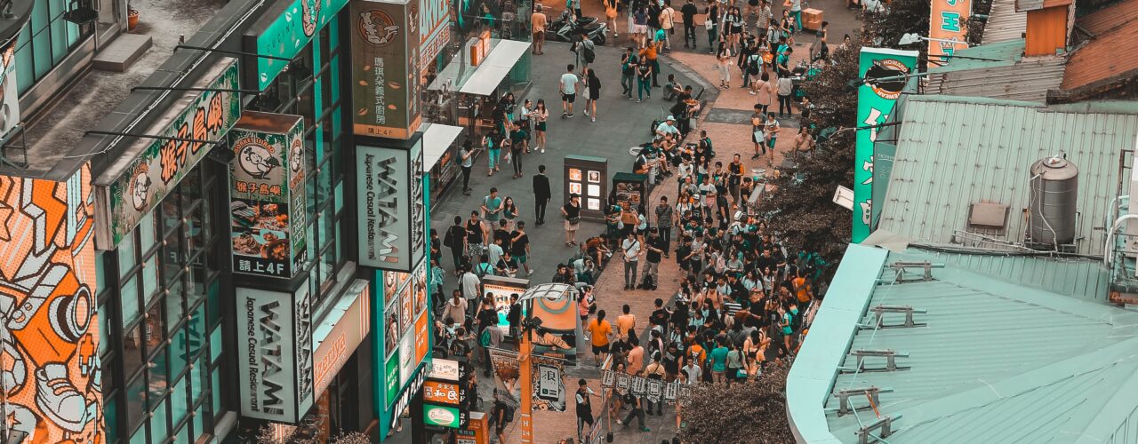 aerial photography of people walking on street between buildings