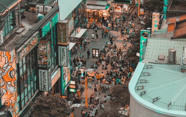 aerial photography of people walking on street between buildings