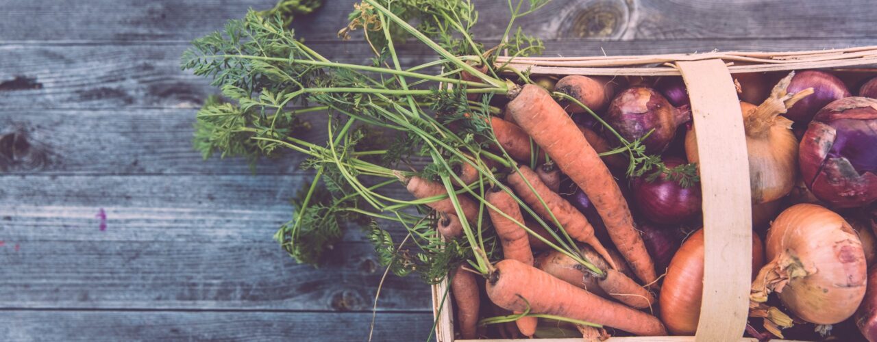 carrots and onions in brown wicker basket