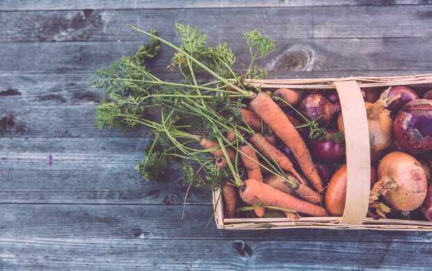 carrots and onions in brown wicker basket