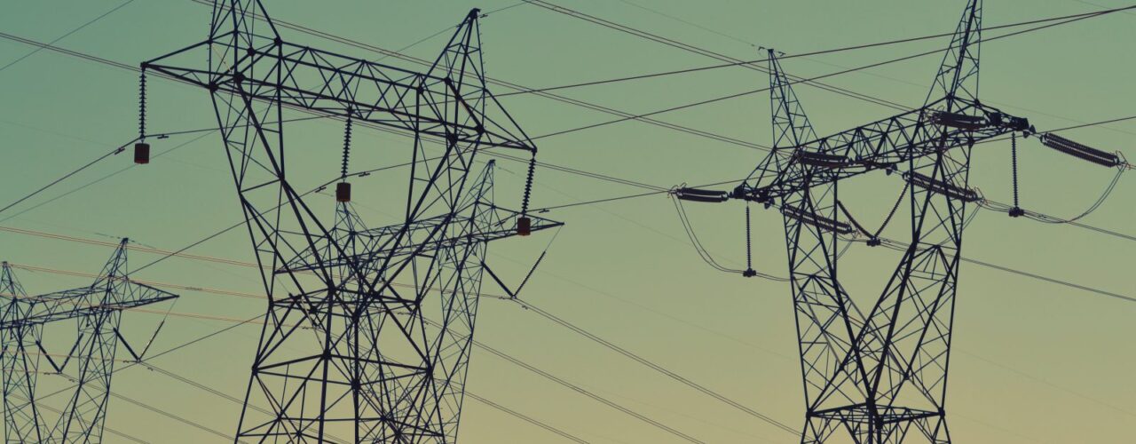 black transmission towers under green sky