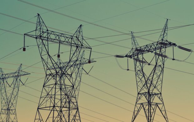 black transmission towers under green sky