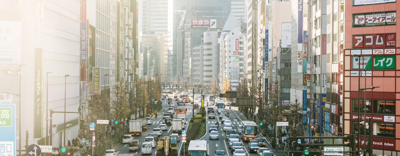 highway road filled with cars surrounded by high rise buildings