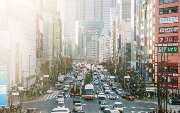 highway road filled with cars surrounded by high rise buildings