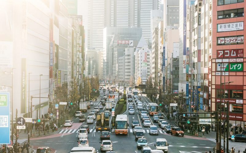 highway road filled with cars surrounded by high rise buildings