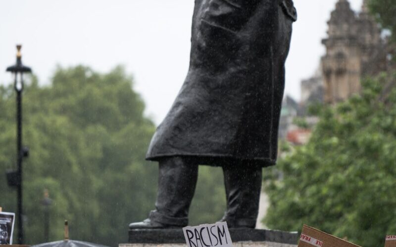 person in black coat holding brown paper bag