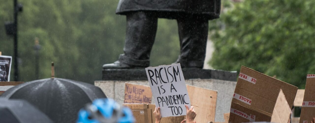 person in black coat holding brown paper bag