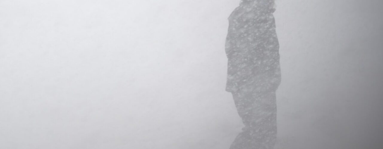 silhouette of man in snow storm