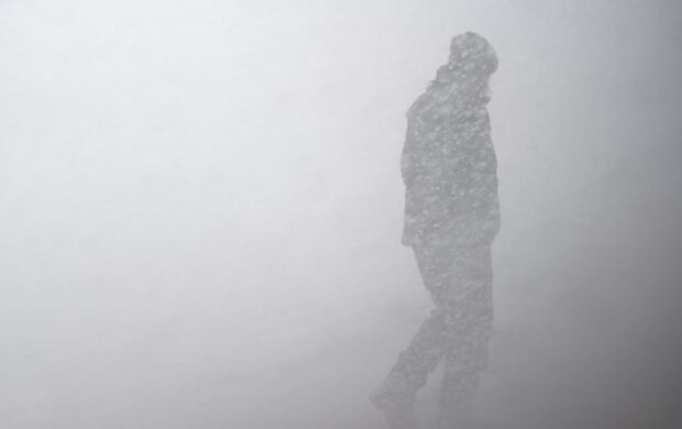 silhouette of man in snow storm