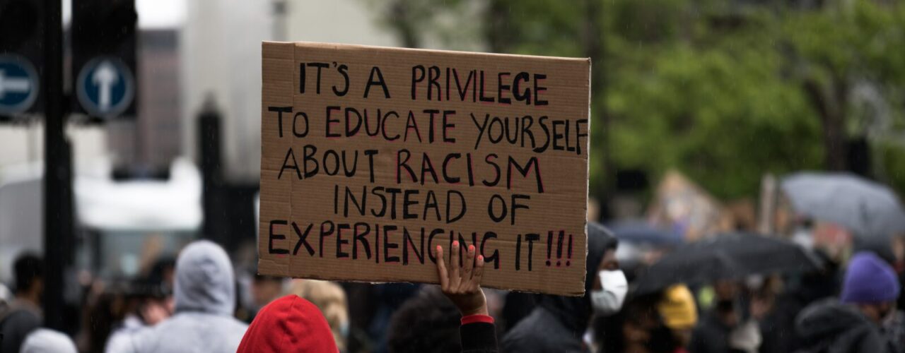 people holding brown wooden signage during daytime