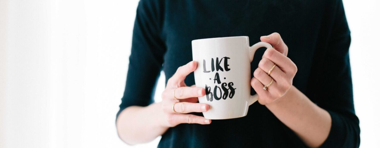 woman holding white mug while standing