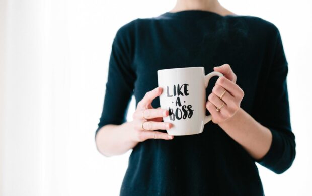 woman holding white mug while standing