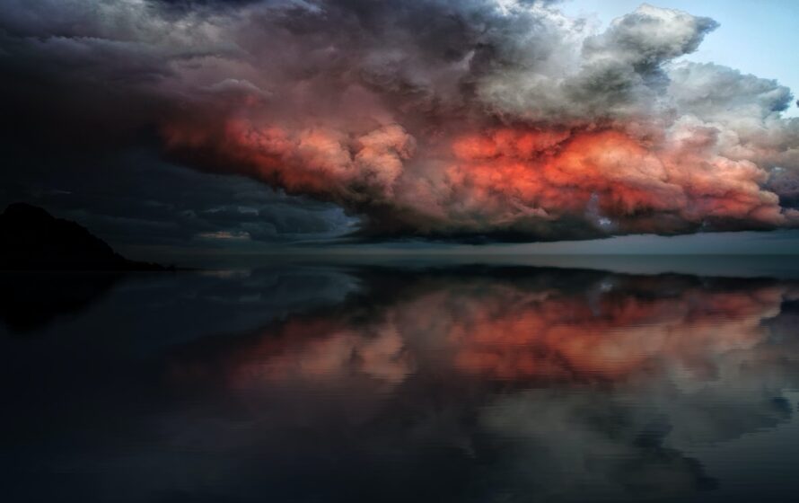 body of water under red and white clouds