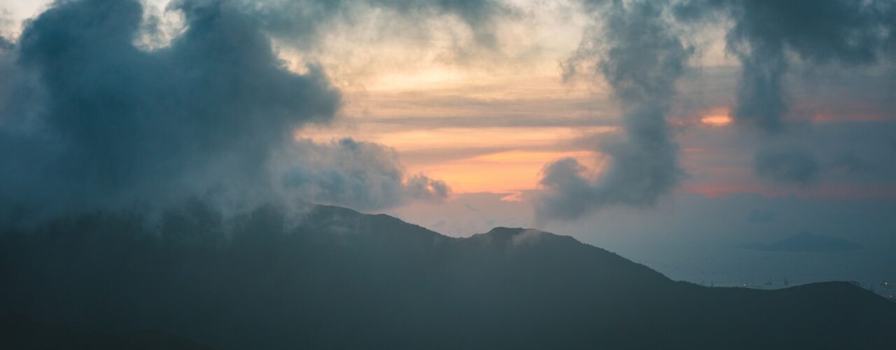 silhouette of mountain under cumulus clouds