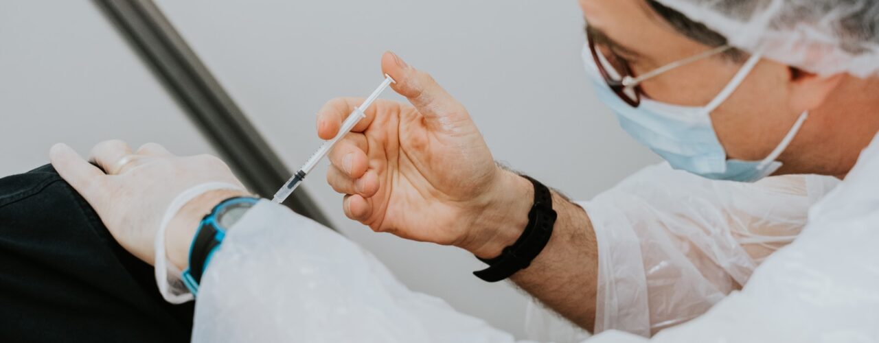 person in white long sleeve shirt holding gray pen