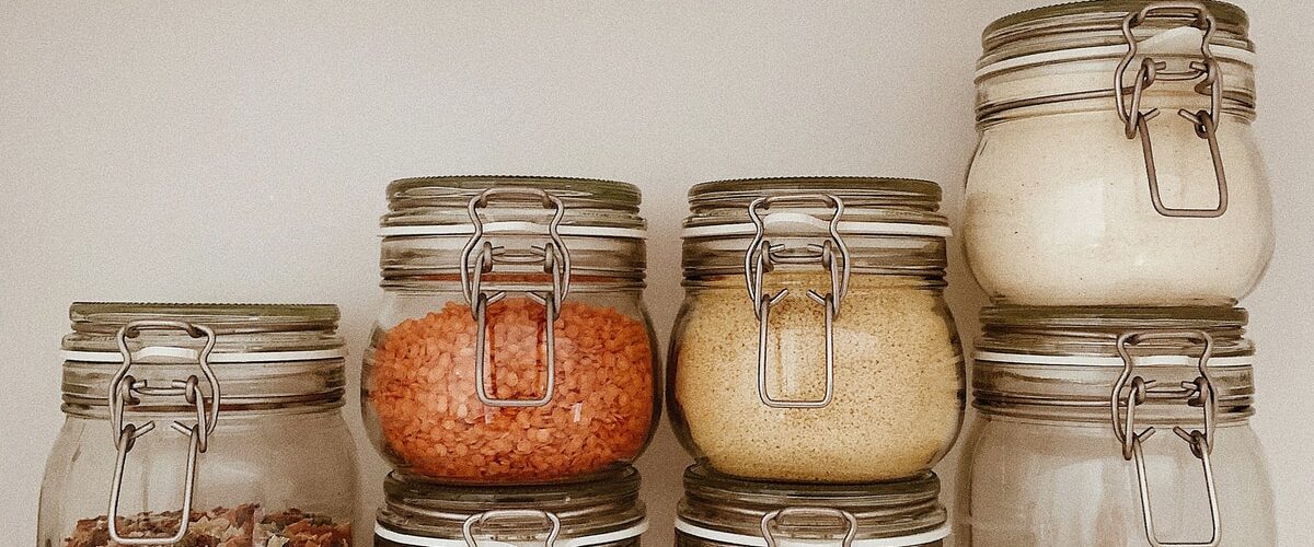 three clear glass jars with brown and white stones