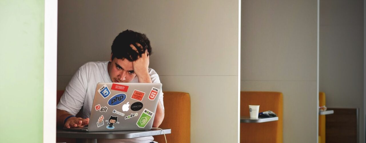 man wearing white top using MacBook