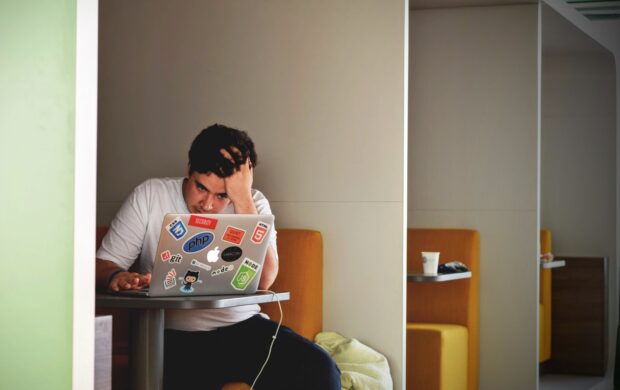 man wearing white top using MacBook