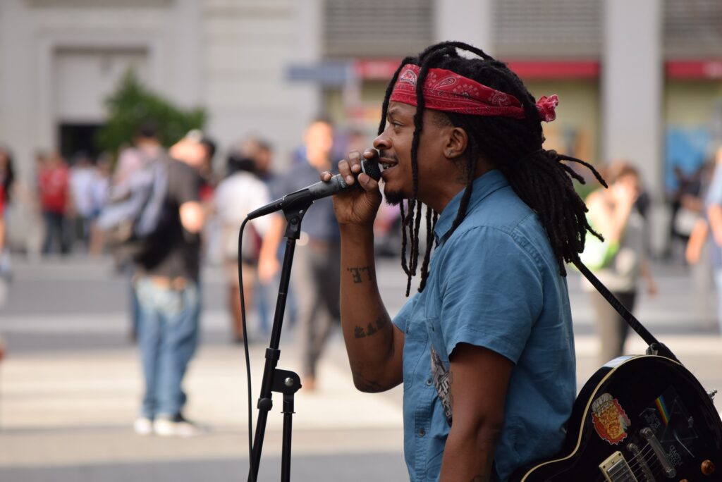 selective focus photography of man using microphone near people at daytime