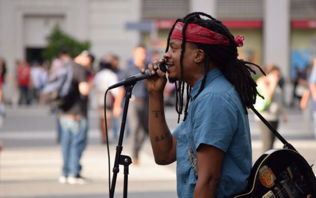 selective focus photography of man using microphone near people at daytime