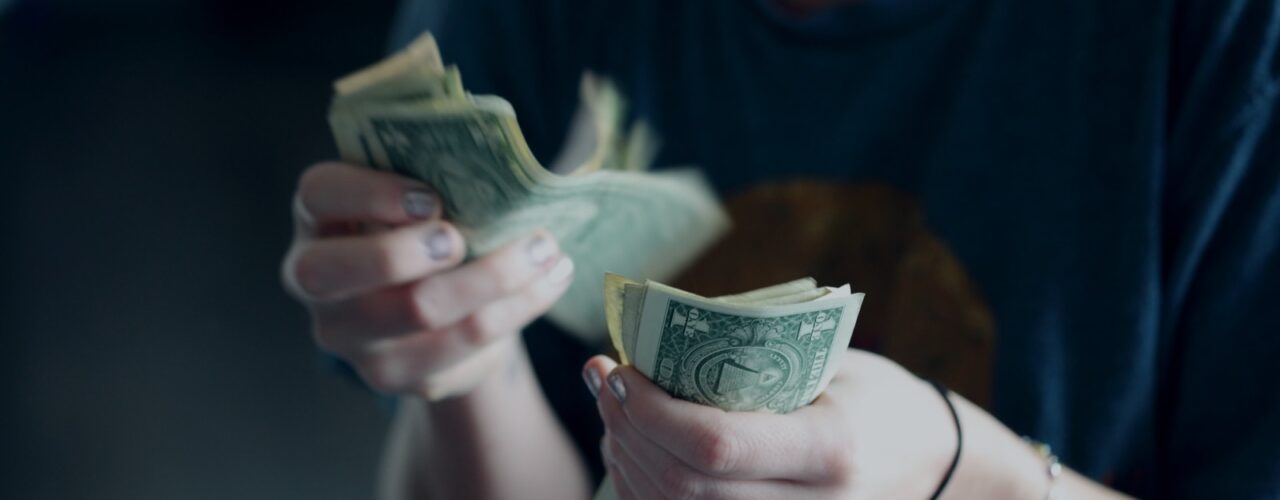 focus photography of person counting dollar banknotes