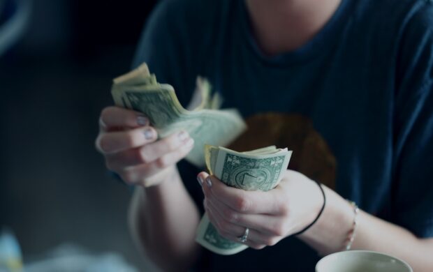 focus photography of person counting dollar banknotes