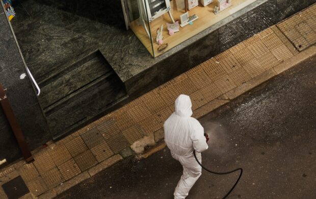 man in white thobe walking on sidewalk during daytime