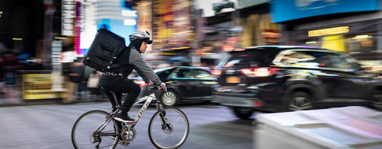 man riding bicycle near vehicles