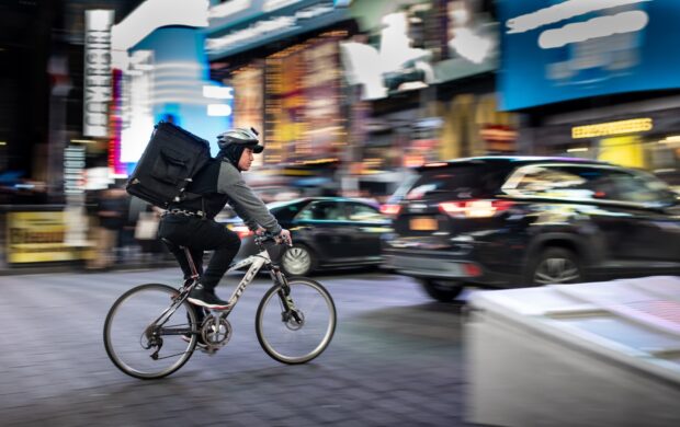 man riding bicycle near vehicles