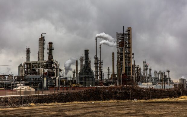 factories with smoke under cloudy sky