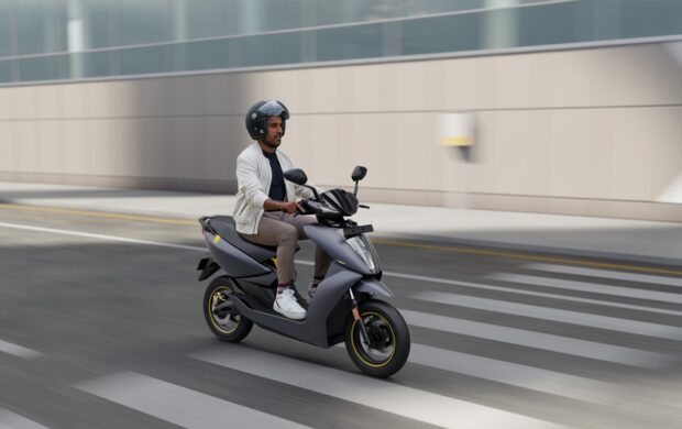 man in white dress shirt riding black motor scooter