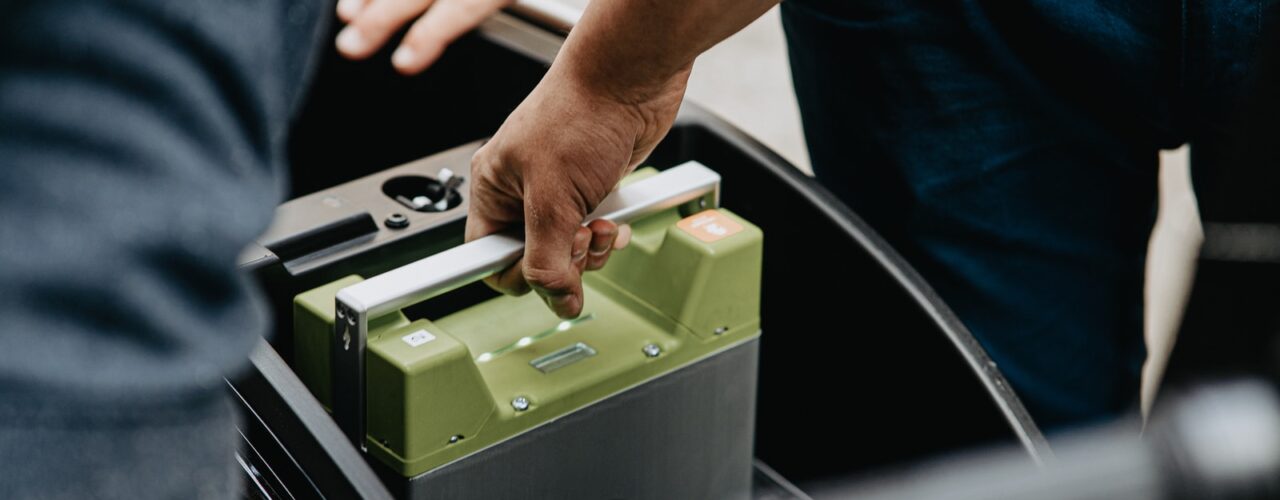 person holding black and green electronic device