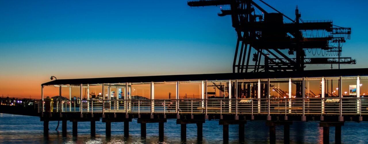 black wooden dock on body of water during sunset