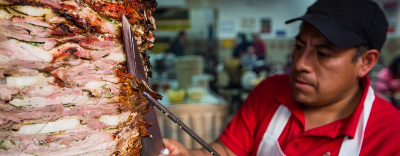 man in red and white polo shirt holding stainless steel fork