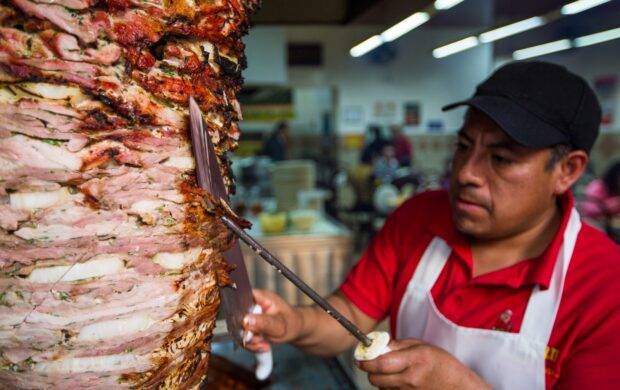 man in red and white polo shirt holding stainless steel fork