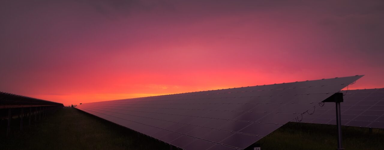 black solar panel under red and gray clouds