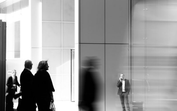 grayscale photo of people walking towards building