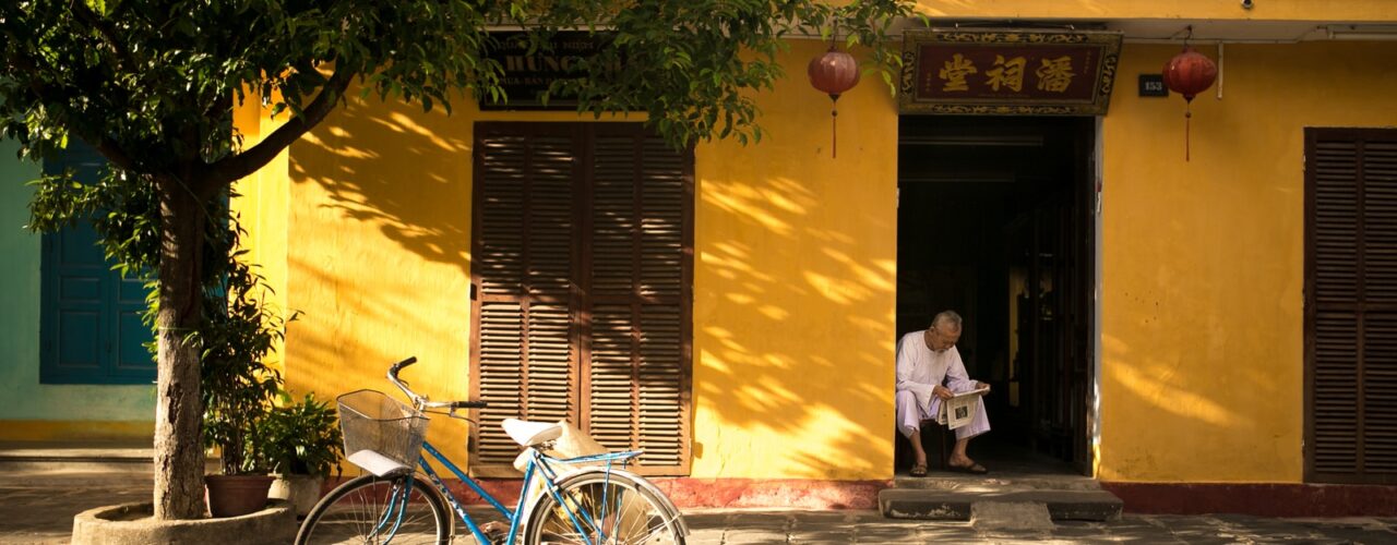 man sitting near door way reading paper