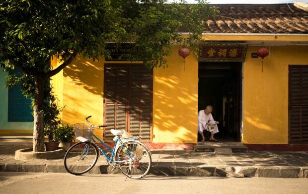 man sitting near door way reading paper